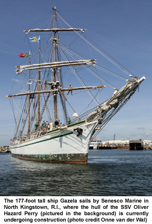 The 177-foot tall ship Gazela sails by Senesco Marine in North Kingstown, R.I., where the hull of the SSV Oliver Hazard Perry (pictured in the background) is currently undergoing construction (photo credit Onne van der Wal)