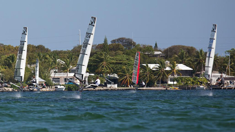 The Nationals fleet screams downwind toward the beach in one of half a dozen impromptu races after official racing was cancelled on Sunday in front of the Upper Keys Sailing Club.  Key Largo, FL. (photo credit to read 2014  Meredith Block/US Moth Class)