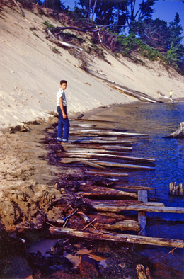 Jack Sheridan stands on Singapore era slabs protruding from the sand. ca. 1953 (Image: Jack Sheridan)